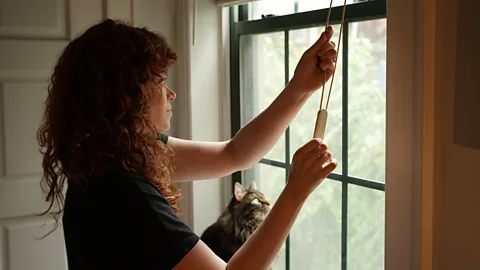 Blackout blinds being opened to let in morning light as part of natural wake routine